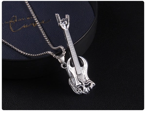 Close-up of rock guitar pendant with gothic patterns and a devil horn gesture handle