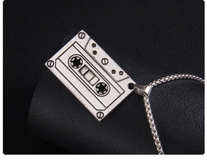 Détail d'un pendentif cassette rétro avec finition argent antique sur chaîne vénitienne