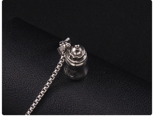 Gros plan du collier pendentif biberon argenté avec échelle 100/80 sur cuir noir