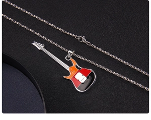 Vue détaillée d'un pendentif guitare tricolore avec émail rouge, orange et noir