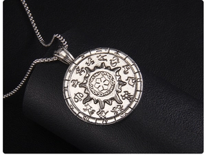 Close-up of vintage stainless steel solar compass pendant with zodiac relief details
