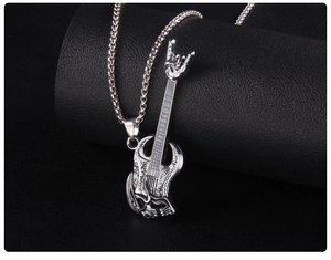 Macro shot of stainless steel guitar pendant with rock gesture and skull relief on leather