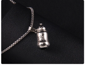 Détail macro du pendentif biberon en acier inoxydable argenté avec graduations gravées