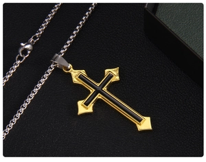 Gros plan détaillé d'un pendentif en forme de croix bicolore avec chaîne box argent