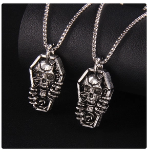 Gros plan de pendentifs cercueil punk avec motifs de crâne et rose sur chaînes carrées