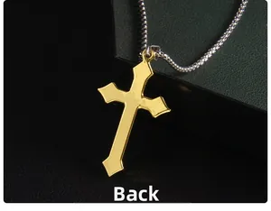 Détail de la face arrière lisse d'un pendentif croix dorée sur une chaîne en argent