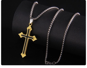 Gros plan du pendentif croix noir et doré sur une chaîne argentée avec cuir luxueux