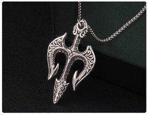 Détails macro du pendentif trident vintage avec textures baroques complexes et gravures