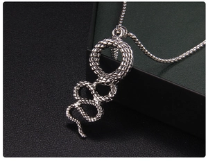 Detailed macro view of snake pendant necklace with intricate silver scale textures