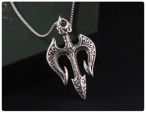 Vue macro d'un pendentif trident vintage avec gravure sur un fond en cuir noir