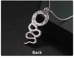 Macro shot of silver stainless steel snake pendant showing detailed back texture and ball chain