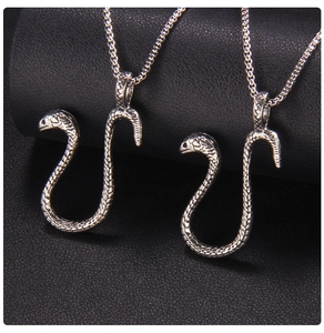 Macro shot of silver snake pendants featuring detailed scales on an O-chain necklace