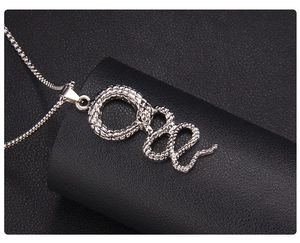 Detailed close-up of a silver snake pendant necklace with intricate metallic scales