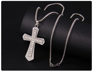 Macro detail of silver cross pendant with sparkling rhinestones on a wheat chain