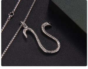 Detailed view of silver snake pendant with scale texture on black leather background