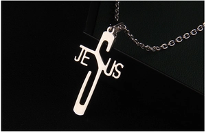 Detailed macro shot of silver hollow Jesus cross pendant in polished stainless steel