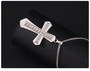 Detailed macro view of silver cross pendant with double-row crystals on box chain