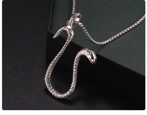 Macro detail of silver snake pendant showing realistic scale texture and eye carvings
