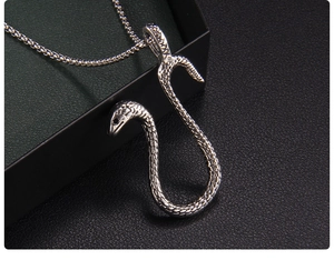 Close-up of a silver snake pendant showing detailed scales and textured metallic finish