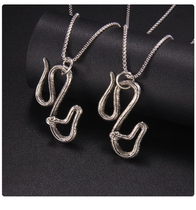 Dettaglio macro di ciondoli a serpente in argento vintage con trama a scaglie