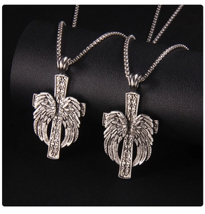 Détail de colliers croix gothiques avec ailes argentées sur fond en cuir noir