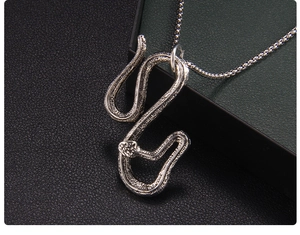 Dettaglio macro del ciondolo a serpente argento con trama a scaglie e catena a sfere