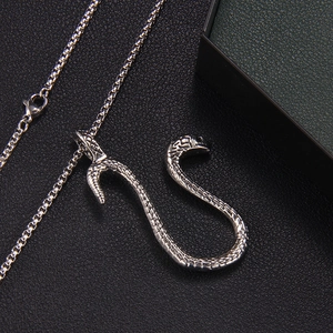 Hip hop silver snake pendant necklace with detailed scales on a black leather surface