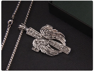 Vue macro des ailes d'ange rétro et du pendentif croix avec texture métallique vintage