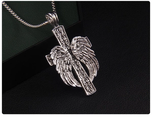 Gros plan du pendentif croix gothique vintage avec aile d'ange et finition argentée oxydée