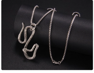 Dettaglio del ciondolo a forma di serpente argento con squame su pelle nera