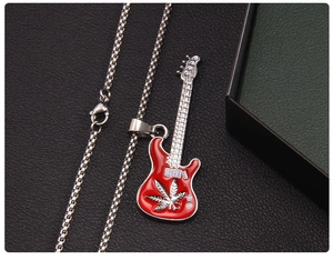 Détail d'un collier pendentif guitare rouge avec motif de feuille sur cuir noir