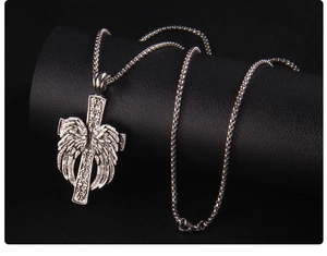 Vue macro du collier croix argenté rétro avec ailes d'ange et textures en relief