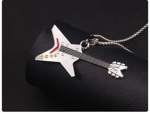 Close-up of Flying V electric guitar pendant with red and yellow enamel details