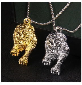 Détail de relief des pendentifs tête de lion dorés et argentés sur cuir noir
