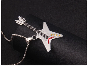 Detail of silver guitar pendant necklace with red and yellow accents on a bead chain