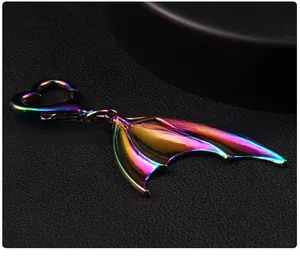Macro shot of iridescent rainbow metal wing pendant with heart-shaped spring clasp