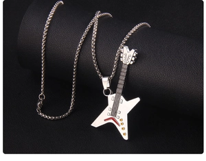 Detail of silver guitar pendant necklace with star motif and red enamel accents