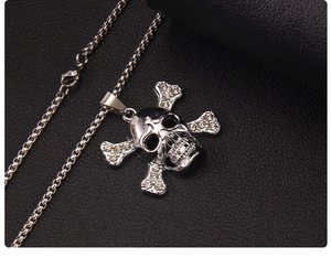 Macro shot of silver skull crossbones pendant necklace with white rhinestones on black leather