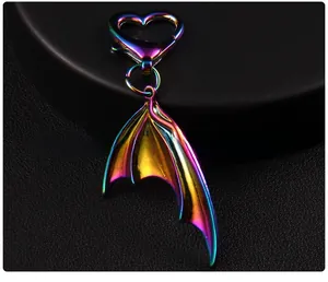 Macro detail of iridescent gradient metal bat wing pendant with heart-shaped clip