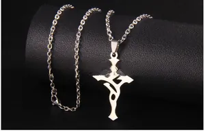 Macro d'un pendentif croix en acier inoxydable argenté avec totem tribal sur fond noir