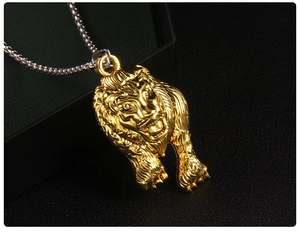 Vue macro du pendentif tête de lion dorée gravée avec une chaîne en métal argenté