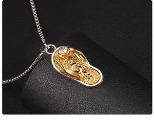 Gros plan du pendentif sandale doré avec strass et chaîne en argent élégante