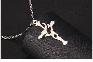 Macro d'un collier croix gothique argenté avec détails sur fond de cuir noir