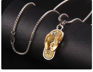 Détail du pendentif tong avec paillettes dorées et cristal sur une chaîne box en acier