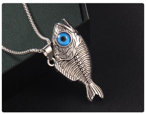 Détail du pendentif vintage en forme d'arête de poisson avec un œil bleu de style punk