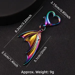 Iridescent gradient mermaid tail keychain with heart clasp on dark textured background