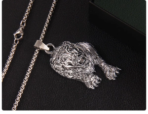 Détail macro du pendentif tête de lion argenté avec texture métallique et chaîne