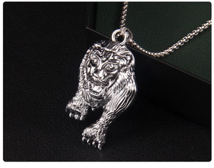 Gros plan détaillé d'un pendentif tête de lion argenté avec gravures ciselées