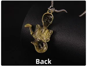 Macro back view of a vintage bronze skull guitar pendant with a silver bead chain