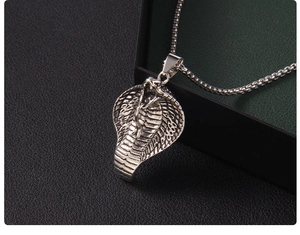 Detailed close-up of retro cobra snake pendant showing intricate scales and metal texture